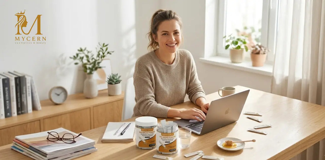 Woman working at her desk with MyCern Bee Bread Powder supplement jars and sachets beside her laptop, supporting daily energy and wellness