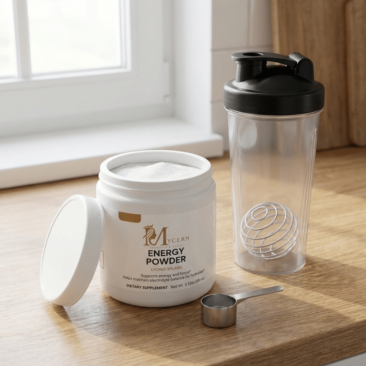 Container of energy powder with a shaker bottle and scoop on a wooden surface.